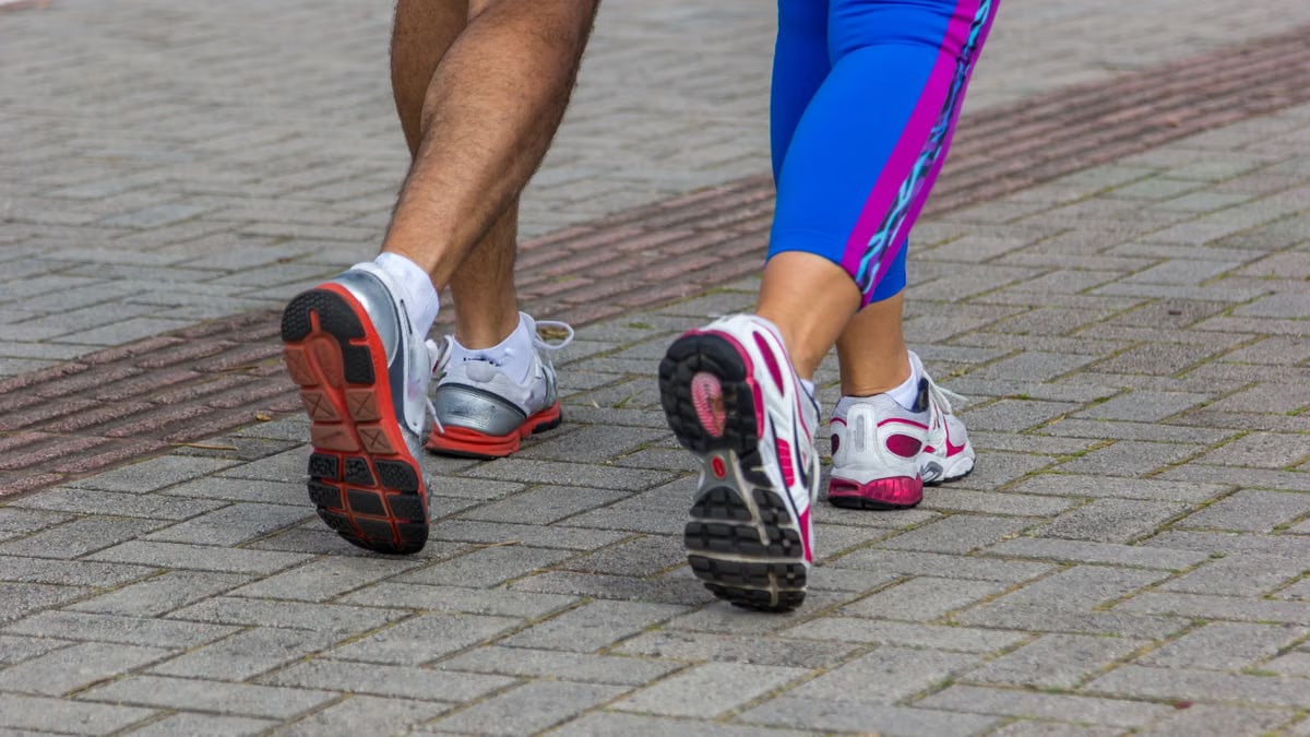People jogging on a city street, giving a close-up of their sportswear shoes. Urban fitness scene.